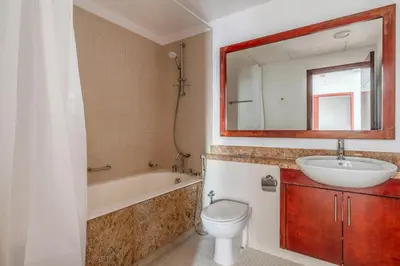 a bathroom with a sink and a toilet and a mirror at Blueground South Ridge Tower 1 city view pool DXB-1409 in Dubai