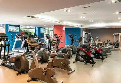 a gym with treadmills and exercise bikes in a room at Blueground South Ridge Tower 1 city view pool DXB-1409 in Dubai