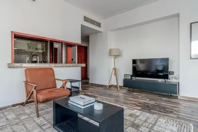a living room with a chair and a tv at Blueground South Ridge Tower 1 city view pool DXB-1409 in Dubai