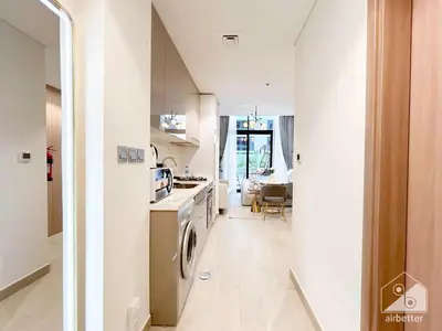 a kitchen and living room with a washer and dryer at Charming Studio with Balcony in Azizi Riviera in Dubai