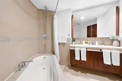 a bathroom with a tub and a sink and a mirror at Skyline Views 2BR Near Burj Khalifa & Dubai Mall with Pool Access in Dubai