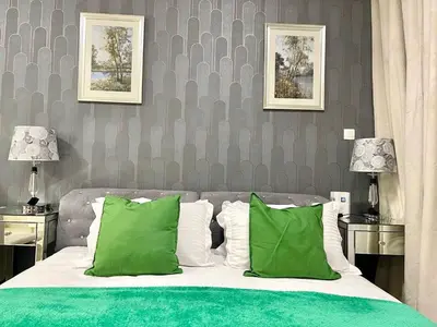 a bedroom with a bed with green and white pillows at Amazing Studio Apartment in The Crescent A Tower IMPZ in Dubai