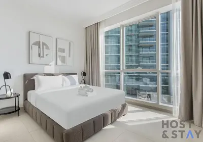 a bedroom with a large bed and a large window at Elegant Beachfront Living at Al Bateen in Dubai
