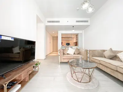 a living room with a couch and a table at Wilton Terrace Charm- Stylish 1-Bedroom in MBR City With a Pool View in Dubai