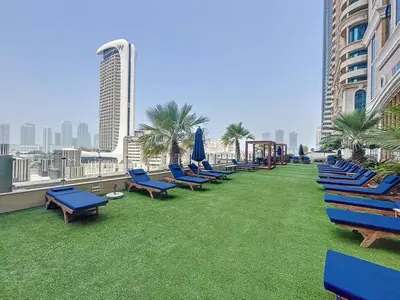a row of blue lounge chairs on the roof of a building at Elite Residence - Cosy One Bedroom Apartment in Dubai
