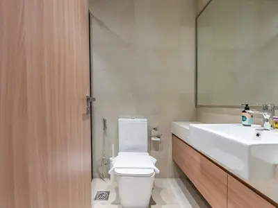 a bathroom with a toilet and a sink and a mirror at Luxury Meydan Escape Condo with City Views in Dubai