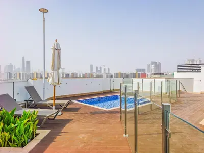 a balcony with a swimming pool on top of a building at Luxury Meydan Escape Condo with City Views in Dubai