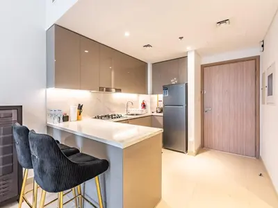 a kitchen with a counter and two bar stools at Luxury Meydan Escape Condo with City Views in Dubai