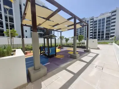 a pavilion with a playground in front of some buildings at Azizi Riviera - 12min from Downtown in Dubai