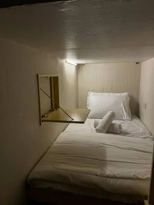a bedroom with a bed with a mirror on it at Capsule Room in Business Bay Near Downtown in Dubai