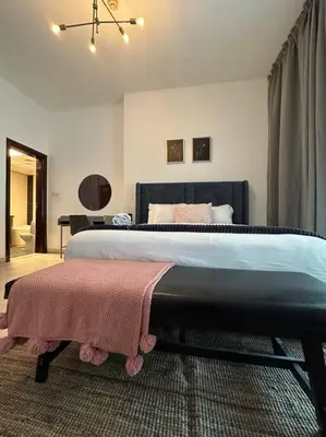 a bedroom with a large bed with a blanket on it at Cozy 2BHK with Marina Views in Dubai