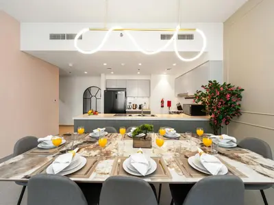 a dining room with a table and chairs and a kitchen at Panoramic Downtown & Fountain views from High Floors at Forte by Propigo in Dubai