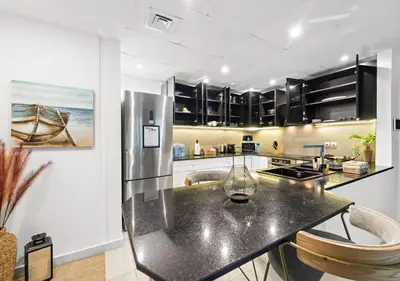 a kitchen with a black counter top and a refrigerator at Burj Khalifa View Downtown Gem, 8 Minutes Walk to Dubai Mall in Dubai