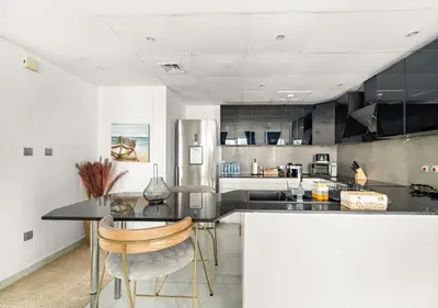 a kitchen with a table and chairs and a refrigerator at Burj Khalifa View Downtown Gem, 8 Minutes Walk to Dubai Mall in Dubai