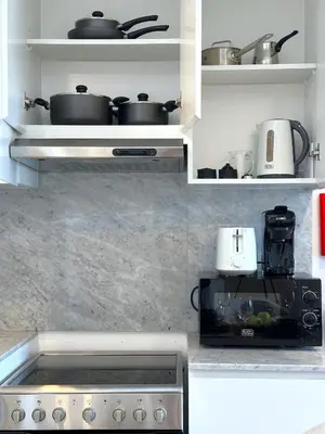 a kitchen with two pots and pans on shelves at MegaLuxury Flat Resort, Amazing Pool, Burj direct View in Dubai