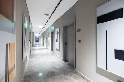 a hallway of an office with white walls and tile floors at Sukoon's Elegant Suite in Dubai