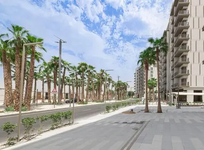 an empty street with palm trees and a building at Sukoon's Elegant Suite in Dubai