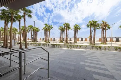 a patio with palm trees and a sidewalk at Sukoon's Elegant Suite in Dubai
