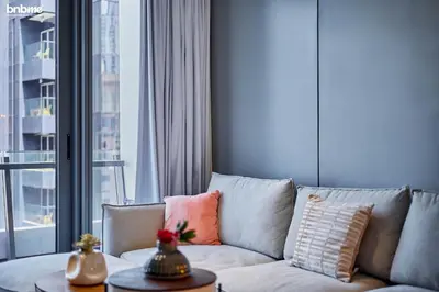 a living room with a couch and a large window at bnbmehomes - Silverene Tower in Dubai