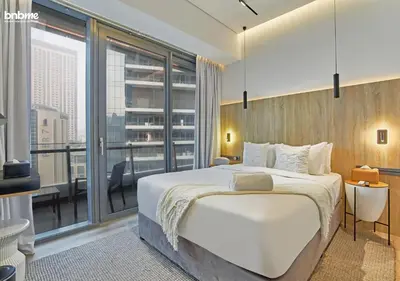a bedroom with a large bed and a large window at bnbmehomes - Silverene Tower in Dubai
