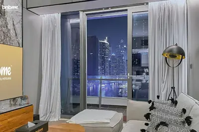 a living room with a window with a view of a city at bnbmehomes - Silverene Tower in Dubai
