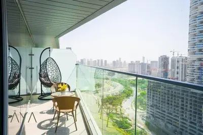 a balcony with chairs and a view of a city at Elegant 1BR Retreat with Rooftop Pool in JVC By ĀYA Boutique in Dubai