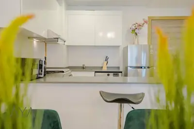 a kitchen with white cabinets and a counter top at Elegant 1BR Retreat with Rooftop Pool in JVC By ĀYA Boutique in Dubai