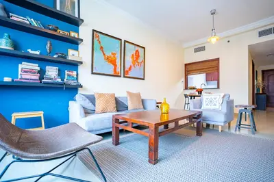 a living room with a couch and a table at RH - Marina View Getaway, Spacious One-Bedroom with Terrace in Dubai Marina in Dubai