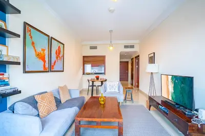 a living room with a couch and a table at RH - Marina View Getaway, Spacious One-Bedroom with Terrace in Dubai Marina in Dubai