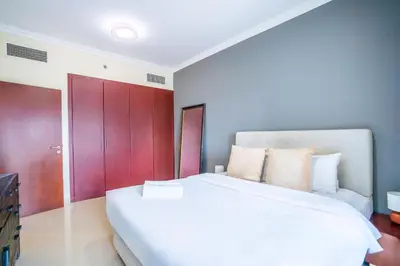 a bedroom with a white bed and red cabinets at RH - Marina View Getaway, Spacious One-Bedroom with Terrace in Dubai Marina in Dubai