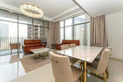 a dining room with a glass table and chairs at Modern 2BR I Partial Burj Khalifa & Boulevard View in Dubai