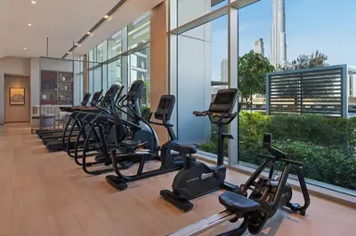 a row of exercise bikes in a gym with a large window at Vida Dubai Mall in Dubai