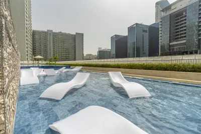 a pool with white chairs on the roof of a building at GuestReady - Stylish living at Reva Residence in Dubai