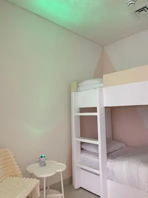 a room with two bunk beds and a table at Downtown Luxe, steps to Burj Khalifa 4BDR in Dubai