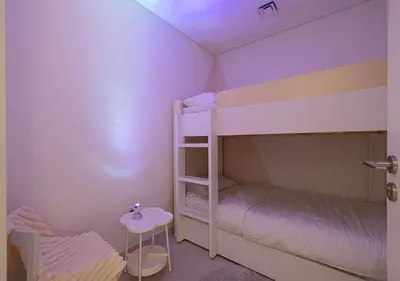 a bedroom with two bunk beds and a stool at Downtown Luxe, steps to Burj Khalifa 4BDR in Dubai