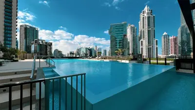 a large swimming pool with a view of a city at Downtown Luxe, steps to Burj Khalifa 4BDR in Dubai