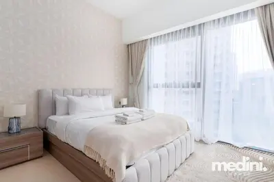 a bedroom with a large bed and a large window at Prime location - ACT 1 ACT 2 - Downtown in Dubai