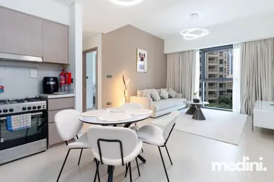 a kitchen and living room with a table and chairs at Prime location - ACT 1 ACT 2 - Downtown in Dubai