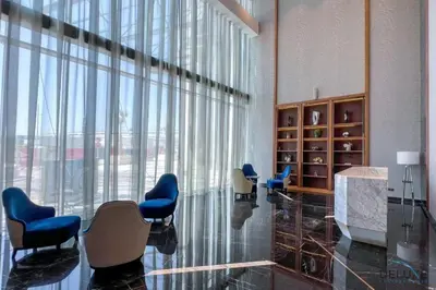 a waiting room with blue chairs and a large window at Special Offer Refined Studio with City Views by Deluxe Holiday Homes in Dubai