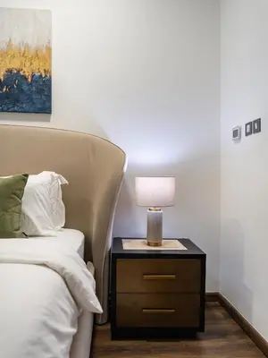a bedroom with a bed and a nightstand with a lamp at Elegant Two Bedroom Apartment with Large Balcony and Panoramic Downtown Skyline & Boulevard Views by Luxury Space in Dubai