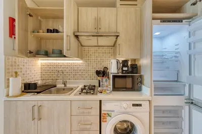 a kitchen with a washer and a sink and a dishwasher at Beachfront Studio Right by Nakheel Mall in Dubai