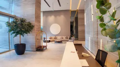 a lobby with a couch and a potted plant at Luxury 2 Bedroom Poolside Haven in Dubai Creek Harbour in Dubai