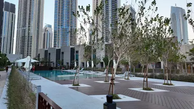 a courtyard with trees and a pool in a city at Luxury 2 Bedroom Poolside Haven in Dubai Creek Harbour in Dubai