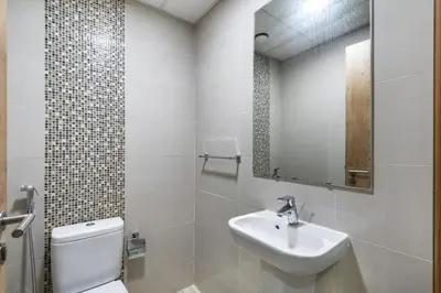 a bathroom with a sink and a toilet and a mirror at ShoresInn - Marvelous Marina View In Dubai in Dubai