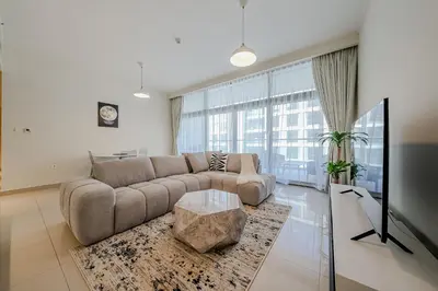 a living room with a couch and a table at Modern 2BDR Apartment I Dubai Hills I City View I Mulberry at Park Heights in Dubai