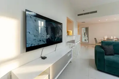 a living room with a large flat screen tv on a wall at Beautiful 2BR I Heart of BLVD I Downtown Dubai in Dubai