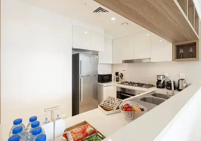 a kitchen with white cabinets and a counter top at Stylish Burj khalifa view 5 Star 4BD Apartment in Downtown with Dubai Mall access - Brand New Apartment in Dubai