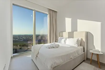 a bedroom with a white bed with a large window at Luxury Stay at Forte Emaar - 5 Min Walk to Burj in Dubai