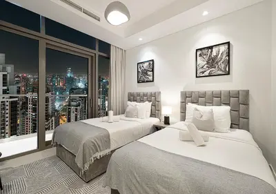 a hotel room with two beds and a window at High Floor Apartment in 5 Star Hotel with Infinity Pool Burj View Gym Spa Sauna in Dubai