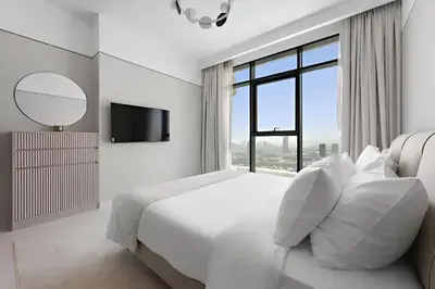 a white bedroom with a bed and a large window at 2BR Beachfront Apt with Stunning Dubai Marina View in Dubai